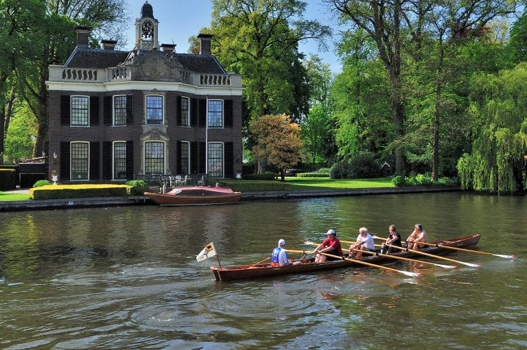 A rowing boat on-the river Vecht passes country house Rupelmonde near Nieuwersluis