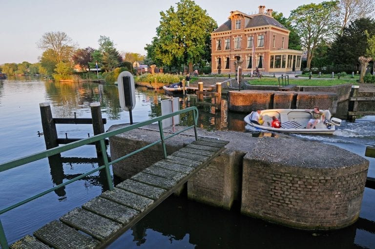 A small boat passes the dam lock in the river Vecht near Nieuwersluis
