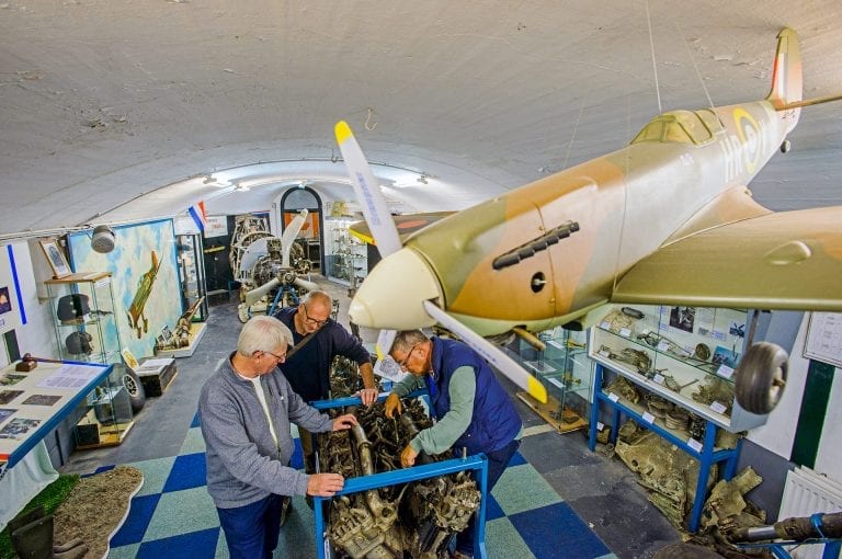 Men are looking at an airplane engine in Museum Crash at Fort at Aalsmeer