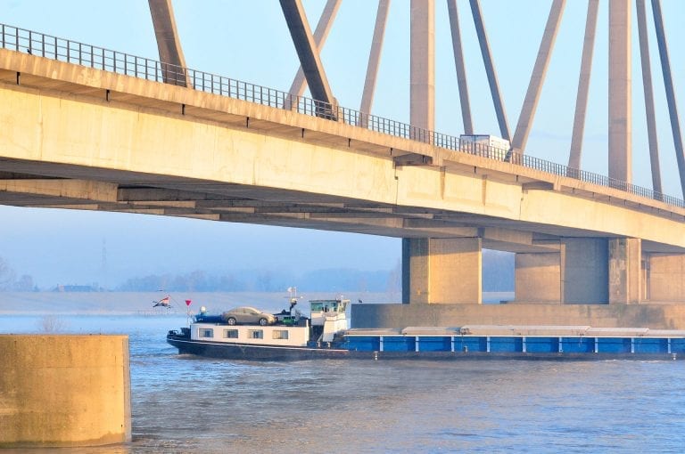 Cargo ship and bridge over Waal at Beneden Leeuwen