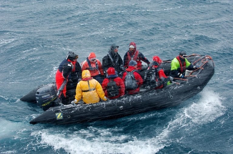 Zodiac with tourists in Antarctic ice blizzard