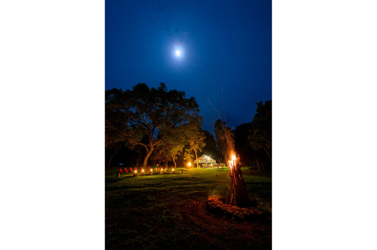 Guests and campfire in evening at Ahaspokuna.