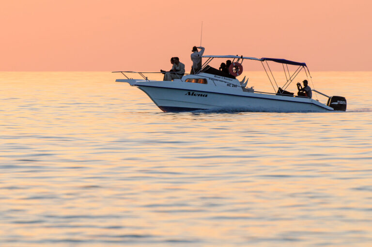 Sunset colors and boat at sea with photographers