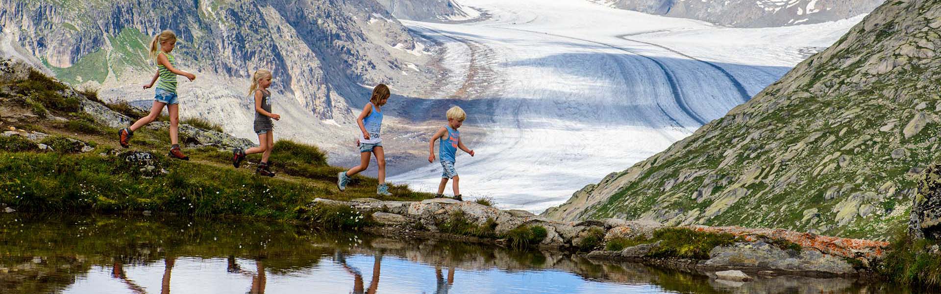 Wandelende kinderen met in achtergrond de Aletsch Gletsjer.