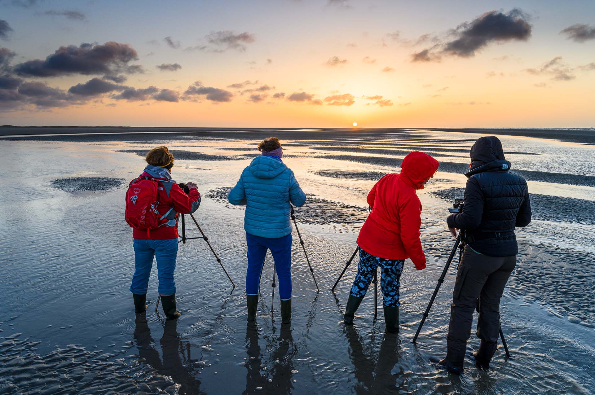 Four participants of a workshop on a beach of Ameland at sunset