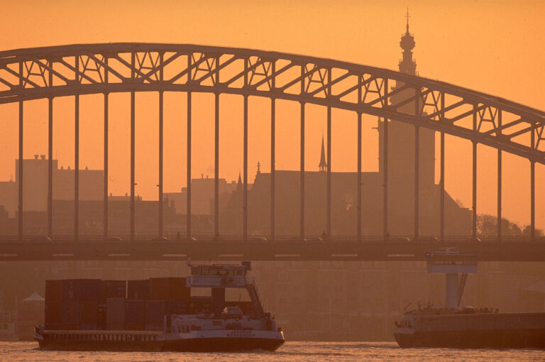 Barges, bridge and church and river Waal at Nijmegen