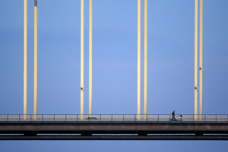 Man and woman cross a bridge with a pram