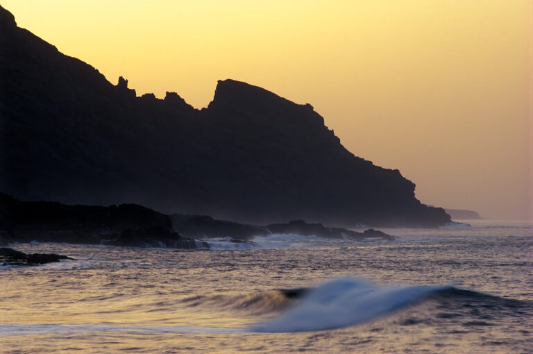 Rocky coast with waves at sunset
