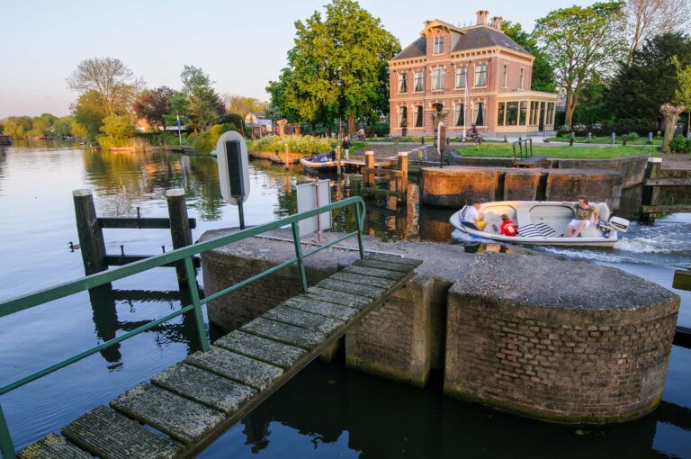 Een bootje vaart door de damsluis in de Vecht.