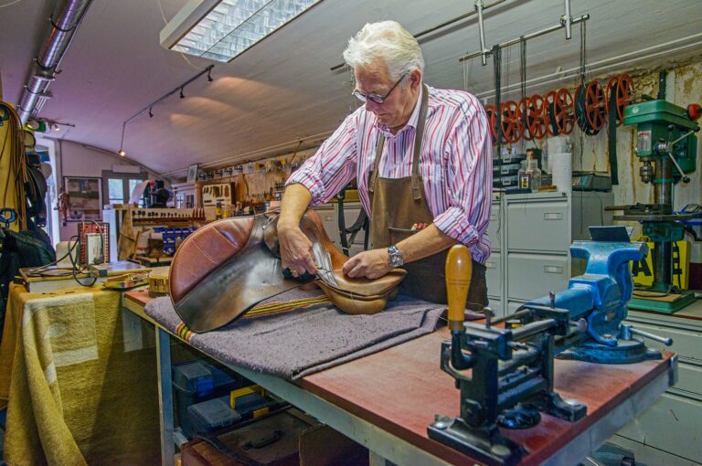 A man is working on a saddle in the saddlery in Fort aan de Liebrug
