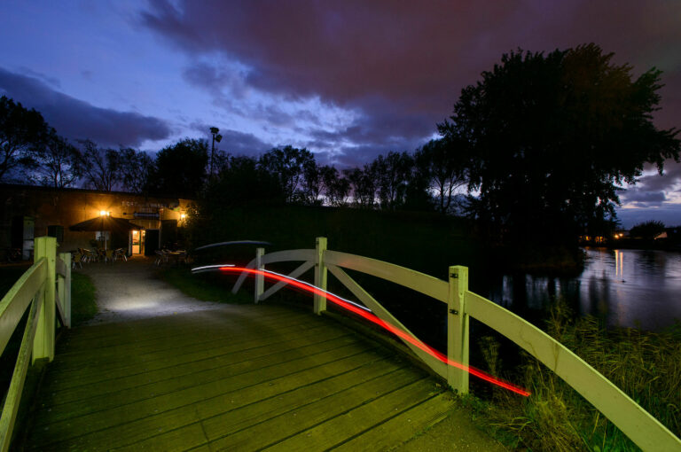 Fietser - achterlicht - arriveert bij Bar het Fort in Fort bij de Kwakel.