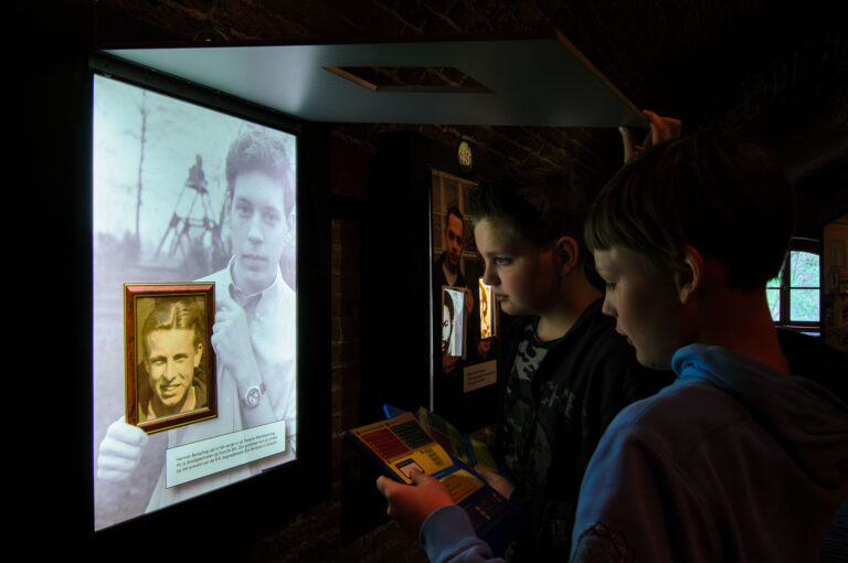 Two students near a screen in the Second World War memorial center.