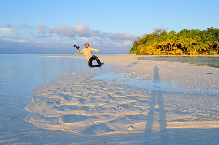 Photographer jumping in to the air in tropical setting