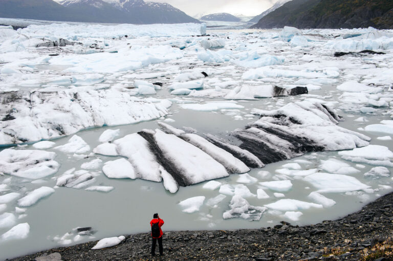 Een toerist kijkt naar de gletsjer van Knik Glacier