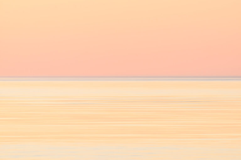 Orange sunset above a flat windless sea