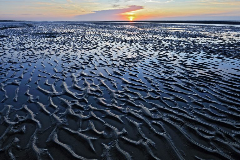 Sand patterns or ripples on the beach of Kwade Hoek at sunset.