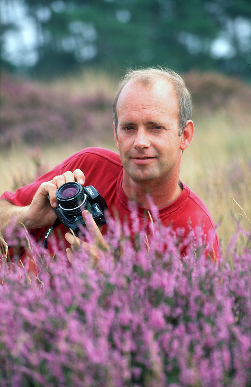 Fotograaf Martin van Lokven met camera liggend tussen de heide.