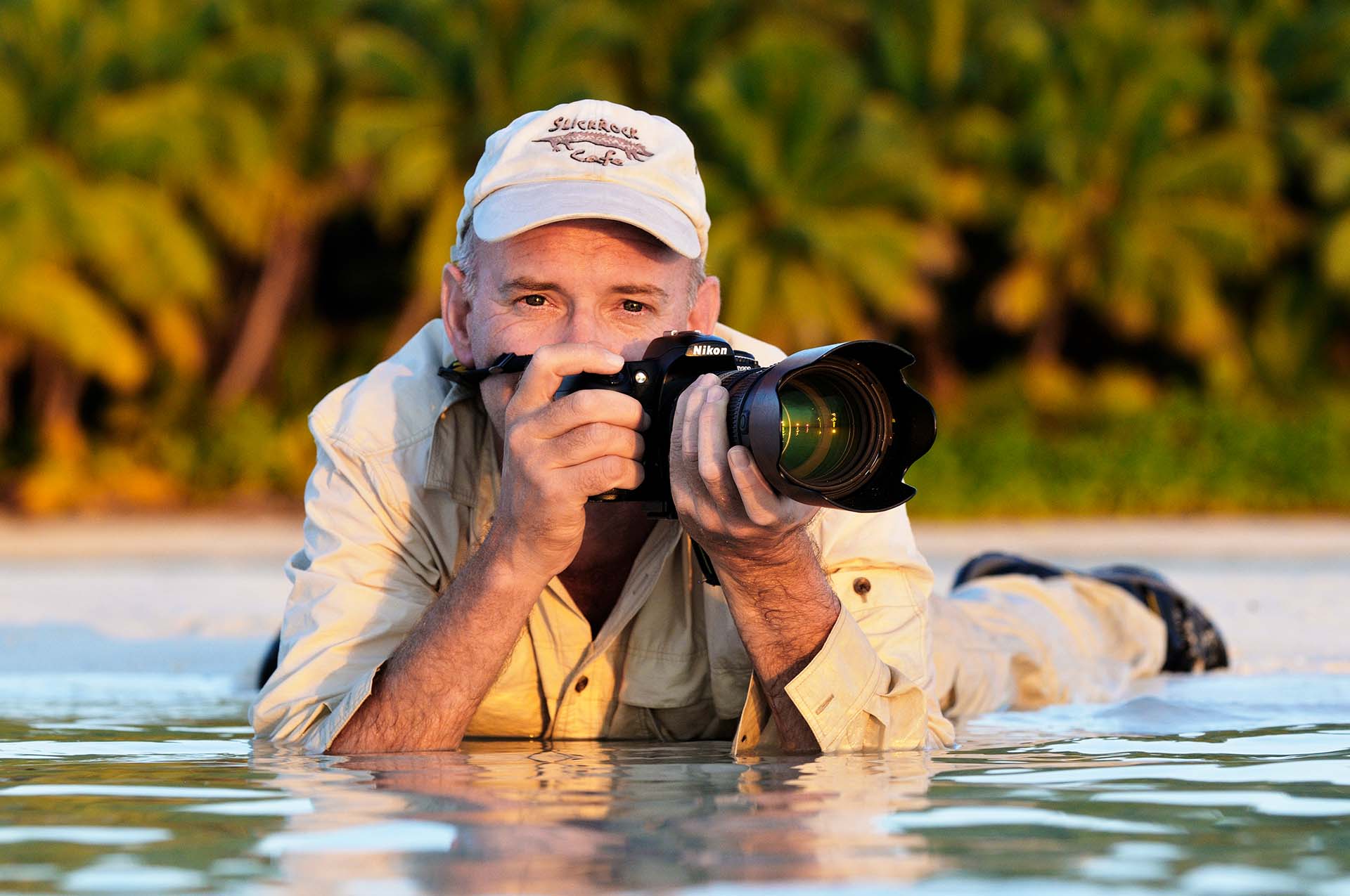 Photographer Martin van Lokven in shallow water with camera.