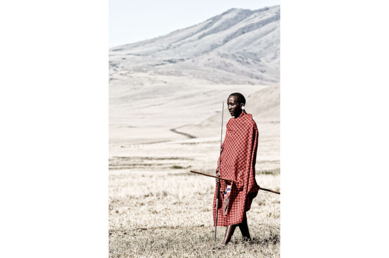 A Masaï man with spear standing in the meadow near the Ngorongoro crater area