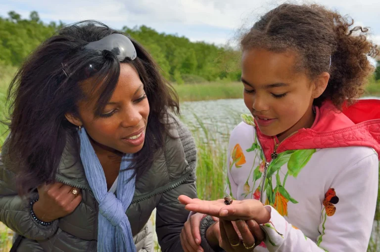 Mother and daughter looking at snail.
