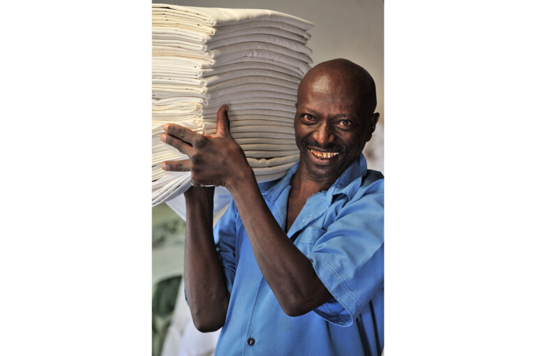 One of the men of the laundry service with sheets