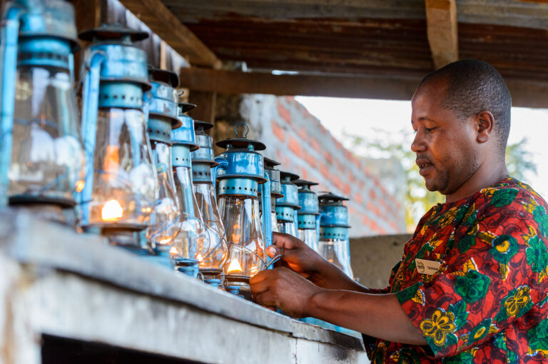 A man is lighting lanterns