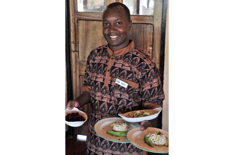 Waiter of Ndutu Safari Lodge with plates