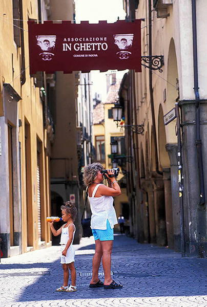 Woman with video camera and child drinking juice from a bottle