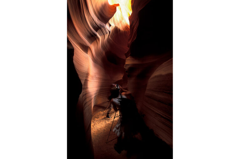 Two tourists taking photos inside Antelope Canyon