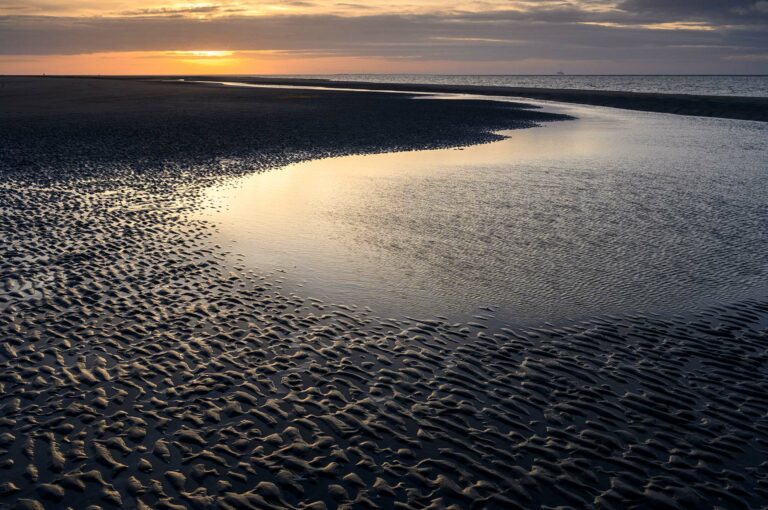 Ripples and gulley on beach at sunset