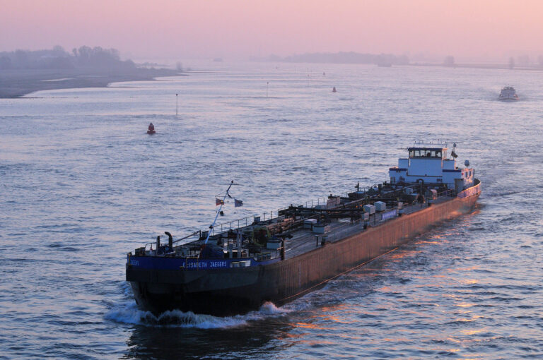 Binnenvaartschip op Waal bij zonsopkomst