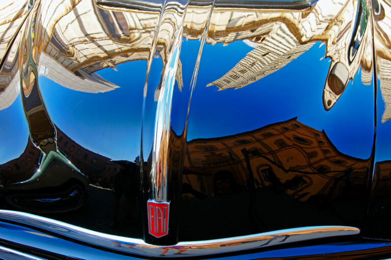 De kathedraal van Siena gespiegeld in de motorkap van een klassieke Fiat