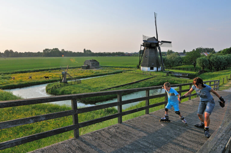 Moeder en zoon op skates, hand in hand een brug overstekend