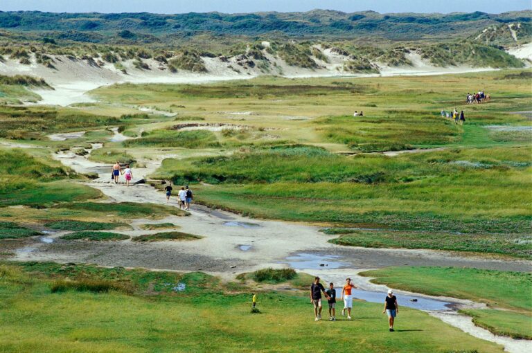 Mensen wandelen in duinen landschap van De Slufter op Texel