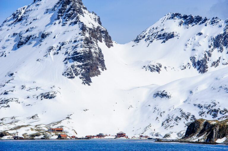 Walvisstation onderaan besneeuwde berg op South Georgia eiland