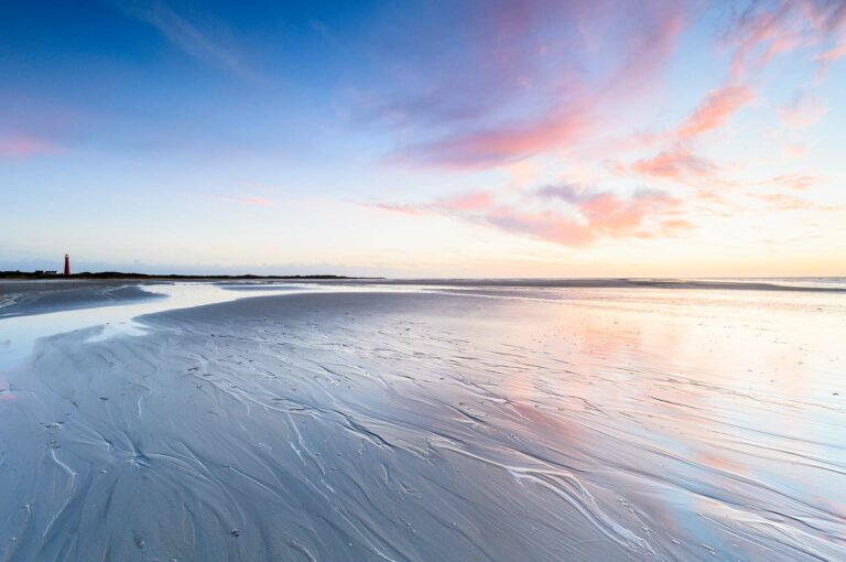 Beautiful soft sunset on beach of Schiermonnikoog with on the left the lighthouse