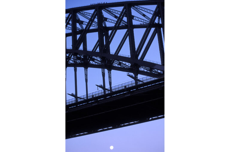 Mensen met hoofdlampjes boven op de Harbour Bridge in Sydney