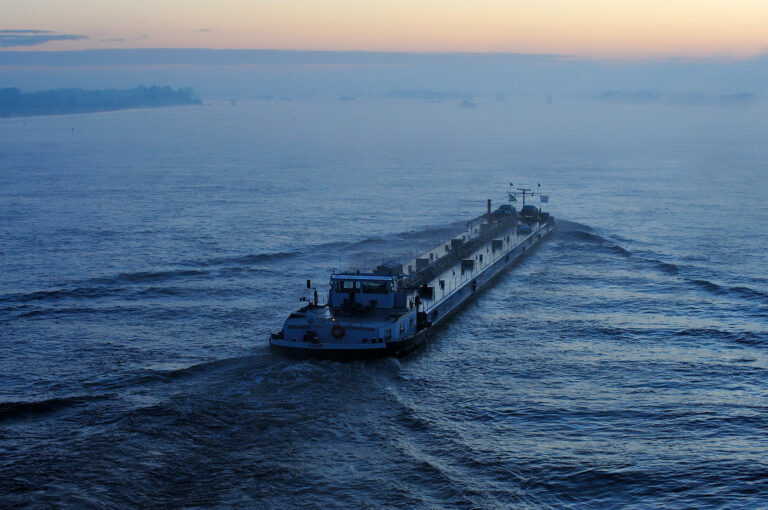 Binnenvaartschip net voor zonsopkomst op Waal