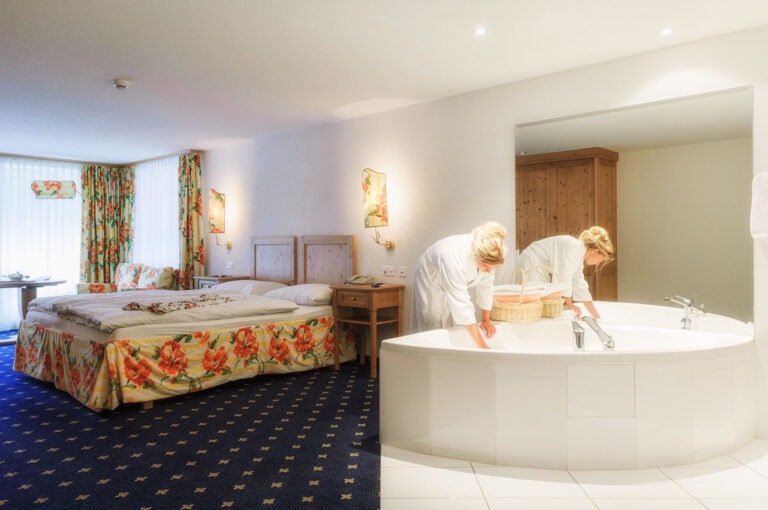 A guest checks the water in a bath of hotel room