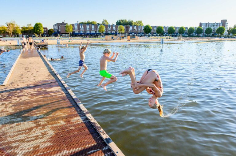 Kinderen springen van een zwemsteiger